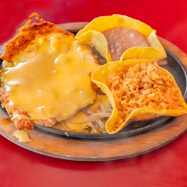 Julio's Mexican Restaurant's sizzling platter with a cheese-covered dish, rice, and refried beans.
